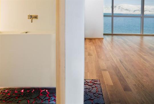 A black lava rock detail flows unobtrusively from wall to floor in the kitchen and bathroom.