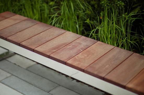 Duo Bench shown with Polished Stainless Steel frame and FSC 100% Jatoba hardwood slats and end at 80 Williams Street, Wellesley, Massachusetts