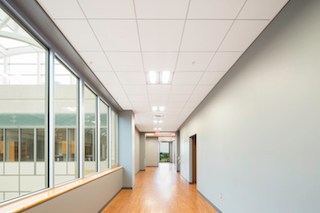 ROCKFON’s ceilings systems create quiet, comfortable learning spaces throughout ASU’s new HSS facility and meet seismic requirements. Arkansas State University’s Humanities and Social Sciences building will greet its first students in the upcoming 2015-16 academic year. AMR Architects designed the building’s exterior to complement the campus’ historic architecture and its modern interior to offer quiet, comfortable learning spaces. Helping accomplish these goals, the new building features ROCKFON’s ceilings systems throughout its 120,000-square-foot, four-story facility. Campus Centerpiece “The new building will be at the heart of every ASU student’s experience on this campus,” said Dr. Lauri Umansky, former dean of the Humanities and Social Sciences (HSS). “Our courses engage students deeply in the world around them. And we have a first-rate faculty. That we will soon be able to offer this kind of high-quality education from a spectacular, state-of-the-art facility is truly exciting.” The HSS building serves as a centerpiece linking Historic Mall to the west, the Caraway Mall to the south, and the new Campus Commons to the north. The structure dramatically defines the edges of multiple plazas and vistas. Inside, it encompasses more than 40 classrooms, laboratories, seminar rooms and approximately 140 faculty offices plus a large atrium for groups to gather. HSS will have 24 percent more space than offered by the building it replaces, Wilson Hall. Arkansas State University’s oldest building opening in 1932, Wilson Hall eventually will be adapted and renovated for other uses. Considered one of the largest instructional buildings on a university campus in the state of Arkansas, HSS has been constructed in four phases with an estimated budget of $36 million. The final phase was substantially completed in June 2015. This phase focused on the interior and site exterior and was completed in 16 months with Tate General Contractors. Tate worked with AMR on all four phases of the project. AMR also received architectural support from CahoonSteiling | Studio of Jonesboro, Arkansas. In total, AMR Architects was involved for more than 10 years on the project. The initial design was bid in 2003 and shelved due to budget constraints. With financial support from the governor and state legislature, the project first broke ground in Sept. 2008. Cost-Effective Performance + Aesthetics During the continued phased construction, the university incorporated some modifications as classroom count and size changed dramatically. Budgets remained top-of-mind in continuing from one phase to the next. AMR Architects employed value engineering methodologies to ensure the construction and materials maintained the project’s performance and aesthetic requirements, as well as provided the most cost-effective selections. In early 2014, as the fourth phase began, AMR Architects’ Jamie Borg, associate AIA, reviewed value-engineered options for the ceiling systems selections. The existing specifications called for an acoustic ceiling tile with a white finish that met the requirements for Seismic Design Categories D, E and F and the high Noise Reduction Coefficient (NRC) of 0.70. ROCKFON meets ASU’s goals for aesthetics, performance, schedule and budget.