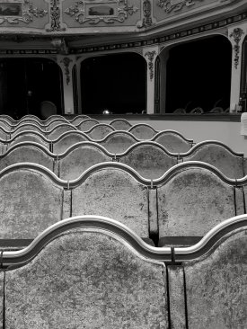 Upright armrests allow for bench seating. Seat back profiles are painted in gold relief, with the backs and recesses in polished wood. Upholstery fabric was sourced to match exactly the colour and feel of the existing seats