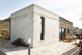 concrete box coming out from a rectangular prism made of natural stone is designed as an acoustically insulated sleeping room.