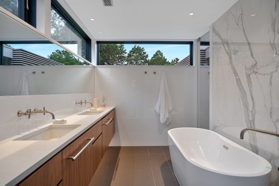 Primary bathroom is wrapped in high windows for privacy and lots of daylight.
