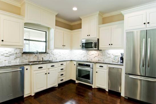 In this white kitchen, a backsplash of travertine adds texture. Location: Dallas, Tex. Designer/Builder: Greenbrook Homes.