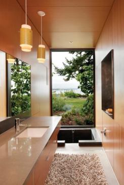 A sunken tub allows bathers to enjoy the view of a floor-to-ceiling window without blocking it. Project: Ellis Residence, Bainbridge Island, Wash.; Architect: Coates Design Architects, Bainbridge Island; Builder: Smallwood Design and Construction, Bainbridge Island