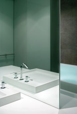 The clean Corian object supports the sink, mirror, and tub.