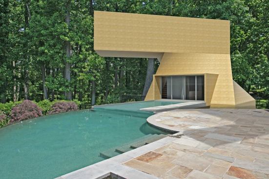 This project is a pool house topped by a studio apartment built adjacent to an existing swimming pool.
