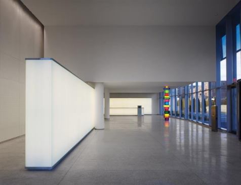The lobby interior. Free standing glass light-box walls of different heights articulate the space and glow from within thanks to dimmable linear fluorescent strips.