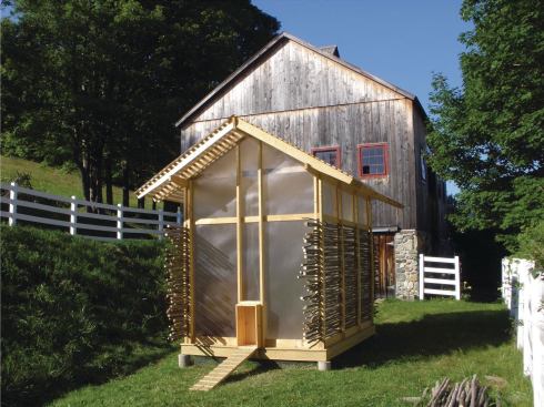 The chicken coop’s pitched roof echoes that of the existing barn behind it.