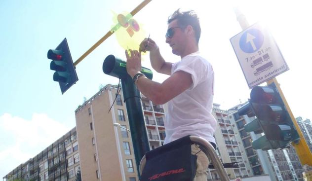 Affixing an owl to a street sign in Zona Tortona.
