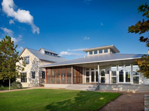 Living spaces occupy the single-story Gulf Coast-style wing. A Hill Country-style “bunkhouse” holds the bedrooms.