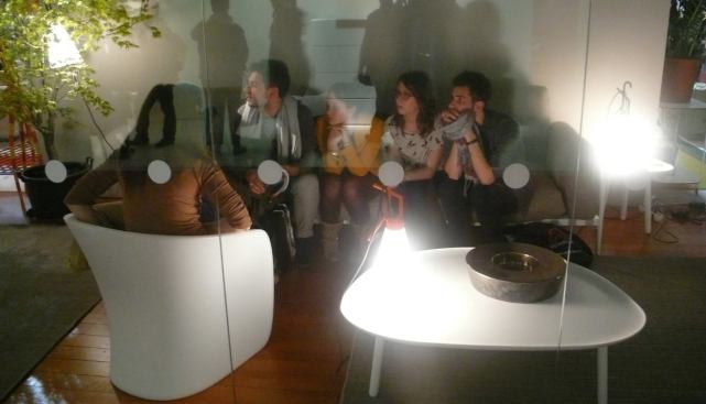 In the Zanotta booth, students huddle around a tabletop light fixture.
