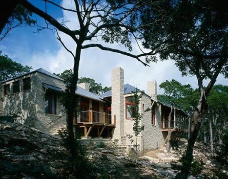 Jennett Country House, Wimberley, Texas – porches along the back of the house overlook a rocky creek and forests beyond