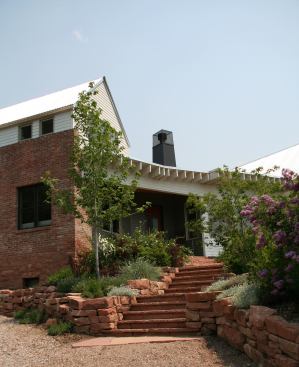 With a main orientation to the south, almost 50 percent of the living space gets direct solar gain. The bedroom’s brick wall helps buffer the intense southwestern sun.