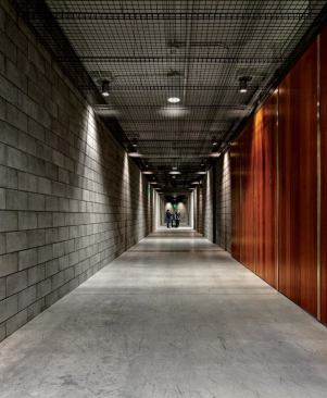 In the museum addition, which houses storage and conservation facilities, lighting designer Jeff Gerwing and his team at SmithGroupJJR wanted to create a contrast to the lighting approach in the galleries. A metal-grate system hangs below the ceiling so that the downlights, which have fluorescent fill, create texture on the walls.