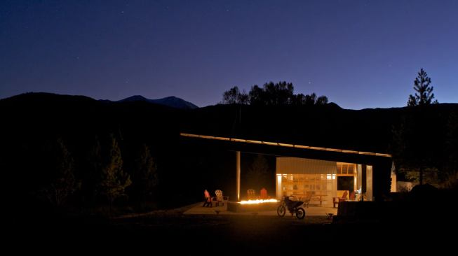 The project shelters a translucent shed and gathering space under a wing-like roof.