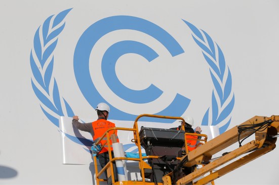 Workers install a logo on the facade of the U.N Climate Conference in Le Bourget, outside Paris.