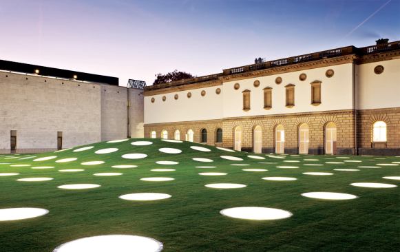 The exterior view of the St&auml;del Museum extension and its convex-shaped green roof is perforated by a grid of 195 porthole skylights.