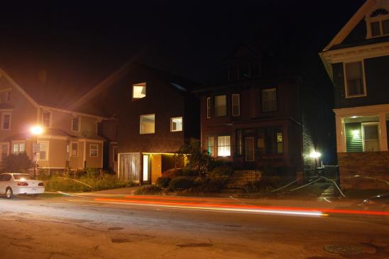 An evening streetscape shows the close proximity of neighboring houses.