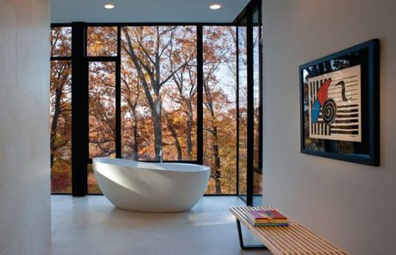 An asymmetrical tub keeps time with its modern environs while providing visual contrast to the vertical trees beyond.

Project: Bloom House, Glen Echo, Md.; Architect: Robert M. Gurney, Washington, D.C.; Builder: Bloom Builders, Bethesda, Md.