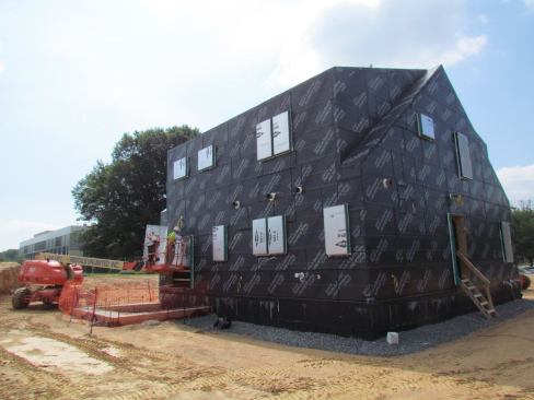 The north and west sides of the facility with the exterior air/moisture barrier in place. The window openings are sealed with foil-faced insulation to facilitate air leakage.