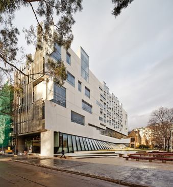 The concrete panels of the south facade are interrupted by windows into the lab and studio spaces.