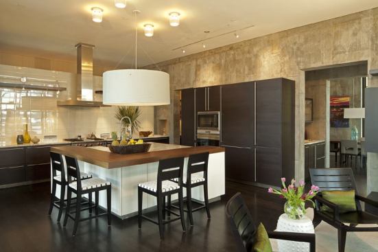 A textured concrete wall and ebony-stained, four-inch oak floorboards serve to anchor the open-plan kitchen.