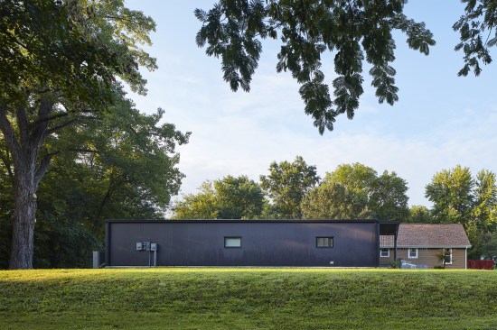 The predominantly opaque envelope on the north side of the house contrasts with a steel screen on the south.