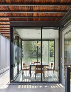 The main entrance (at right) opens off the walkway on the house’s south side.