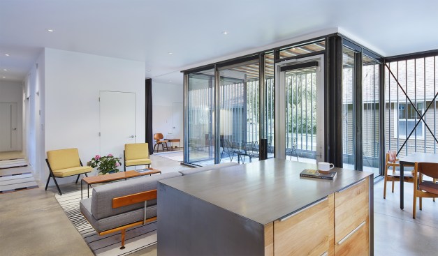 A set of interconnected spaces serves as living and dining room. In an adjacent space (at rear), the owners can accommodate overnight guests by drawing the curtains.