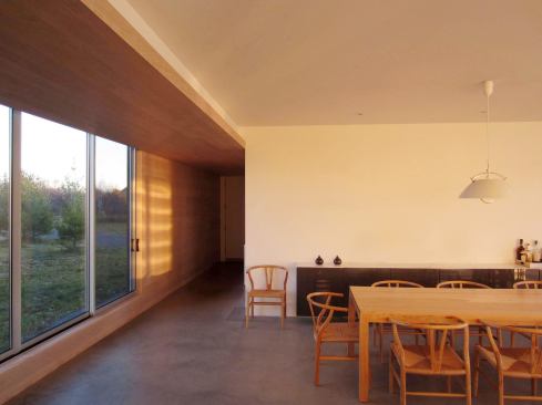 The oak planking modulates the section and adds warmth to the gray and off-white color palette and concrete floors.