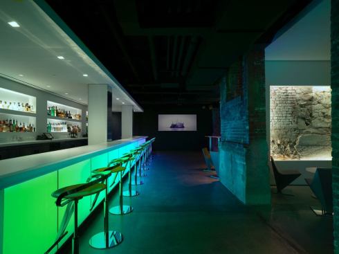 In the main bar, the longer expanse of backlit glass allows for more animated effects that are experienced in part or whole depending on the guest's location. Recessed MR16 downlights have been added for accent on the bar top and glass display.