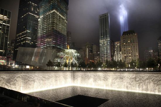 A view of the north tower reflecting pool with the National September 11 Museum in the background.