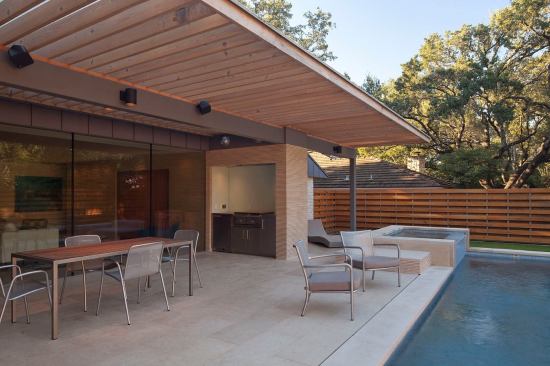 This Austin ranch got a hip, mid-century makeover without adding any extra square footage to the plan, thanks in part to a new patio pool shaded by a generous overhang. Materials used inside the home extend into the outdoor space, helping to forge an interior/exterior connection. Project: Chimney Corners, Austin, Texas; Builder: Melde Specialty Construction, Horseshoe Bay, Texas; Architect: Webber + Studio, Austin