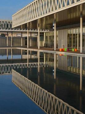 The pools on the ground plane, in front of the stacked office and public space volumes.