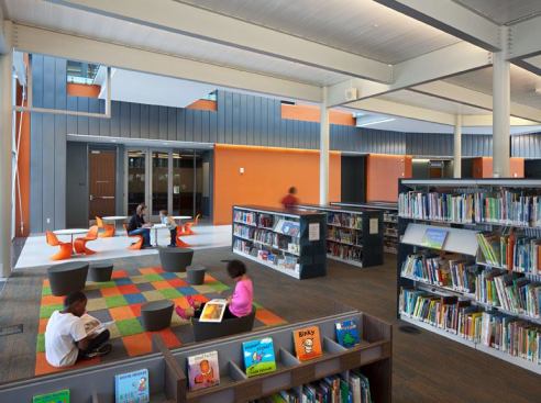 The children’s library area. T5 fluorescents are integrated into the structural support members and indirectly illuminate the ceiling without any socket shadows.