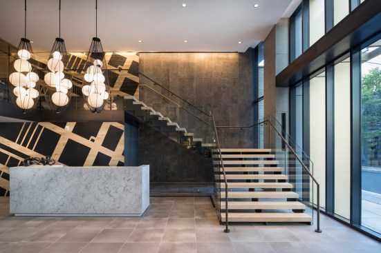 A grand double-height lobby extends into the second-floor co-working lounge.