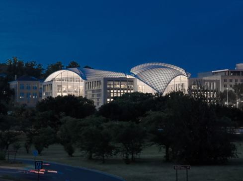 A view of the United States Institute of Peace at night. The building glows from within, doubling as exterior as well as interior illumination.