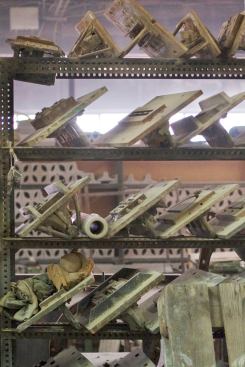 Dies for the extruding machine line the shelves.