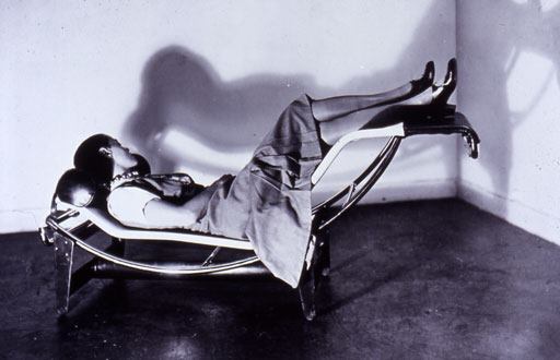 Perriand in 1928, lying upon the tubular-steel chaise longue she designed with Edouard Jeanneret and Le Corbusier
