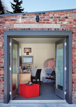 The husband, who uses a wheelchair, gains access to his office by going outside, up the sidewalk, and through this rear entrance.