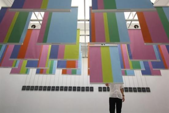 A visitor pulls down one of the 124 project banners in the U.S. Pavilion to get a closer look.