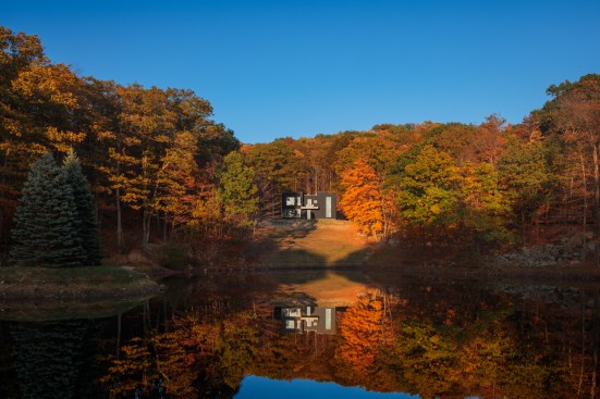 Surrounded by gently sloping hills, the home sits on a flat lot overlooking four wooded acres and a tranquil pond in New York’s picturesque Hudson Valley.