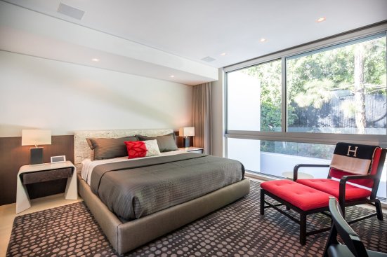 Modern bedroom with floor to ceiling windows at Beverly Hills home.