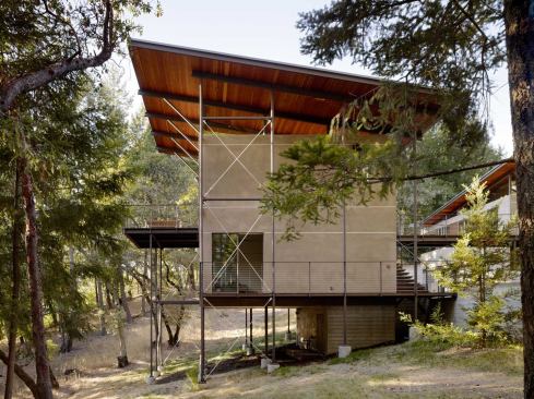 The natural grade pitches away from the main house to the guest house, which rises three stories above grade at its high side.