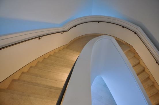 One of the internal connecting stairs in the building illuminated by compact fluorescents hidden in plaster niches that line the stair walls.