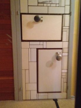 As you move through the exhibit, you might come across pieces of wood combined with worked plaster, framed by metal, or tiles laid around what appear to be drawers.