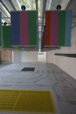 The banners, marked with a barcode system that indicates each project's focus in six key areas, are suspended on a pulley system above a floor that is incribed with a timeline of the history of urban progress.