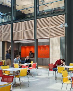 The café serves the internal plaza area. The orange resin panels are washed by lights recessed in the soffit.