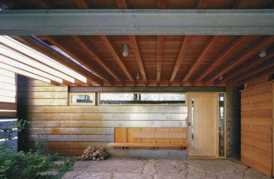 The board-formed concrete on the exposed parts of the foundation is repeated on the fireplace, where individual planks were cast on site and stacked up like logs.