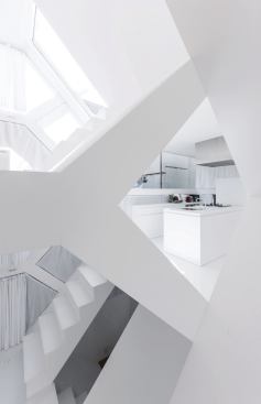 White-painted plaster board covers most of the M.C. Escher–like interior. Hard surfaces are countered by the perimeter curtains and in some spaces by hemp carpet.